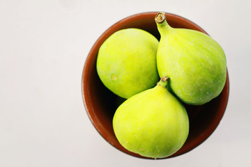 Fresh green figs in a bowl isolated on white background