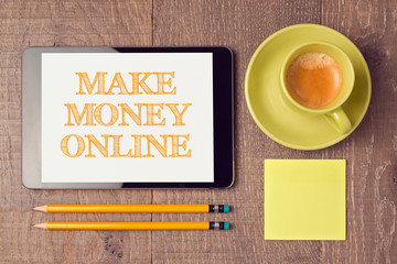 Make money online concept with digital tablet and coffee cup. View from above