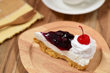 slice of blueberry cheese cake on wooden plate