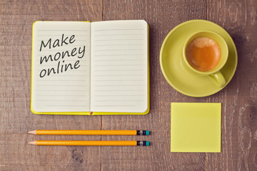 Make money online concept with notebook and coffee cup. View from above