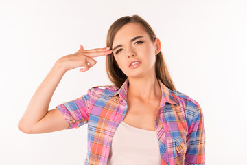 tired girl imitates gun at her temple