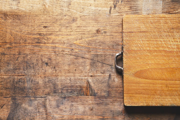 grown old wooden cutting board on a wooden old background. space