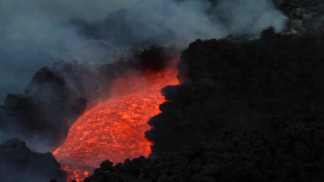 details lava flowing within a channel lava on Mount Etna