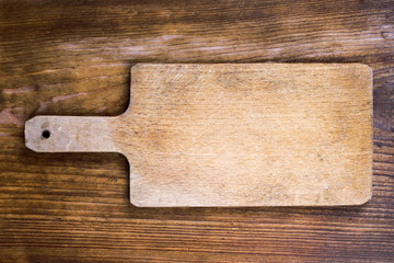 old wooden cutting board on a wooden background