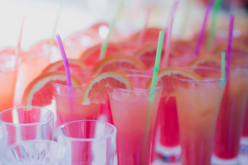 Beautiful row line of different colored alcohol cocktails with mint on a open air party, tequila, martini, vodka with bubbles,and others on decorated catering bouquet table on open air event, picture 