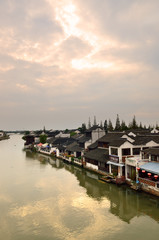 Fototapeta na wymiar Old village by river in Shanghai with boat..