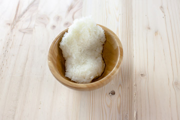 Sticky rice in the wooden bowl on wooden background