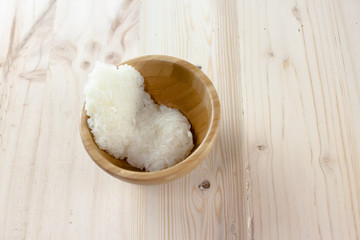 Sticky rice in the wooden bowl on wooden background