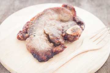 Pork steak on wooden plate