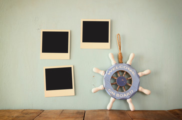 blank instant photos hang over wooden textured background next to vintage wheel