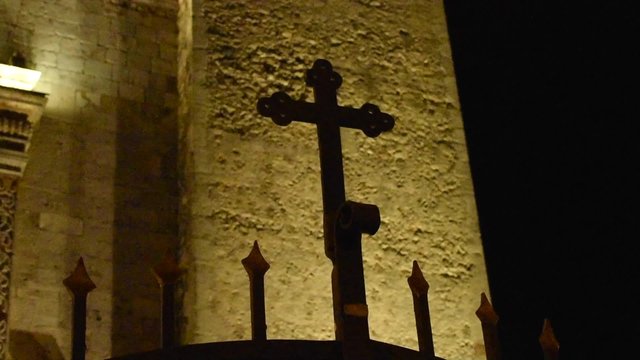 Spooky dark cross at night with old colonial cathedral