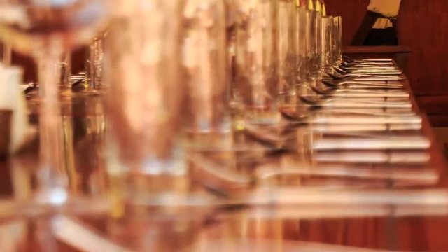 long lines of wine glasses on restaurant table with napkins	