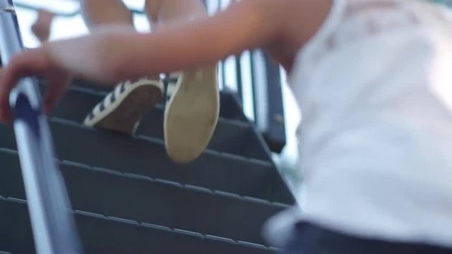 Feet climbing up the stairs of a slide
