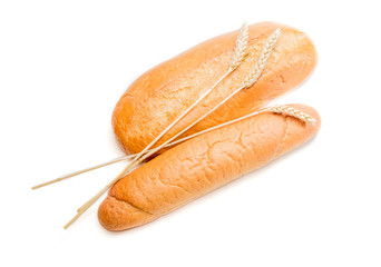 Two various loafs of bread and wheat spikelets