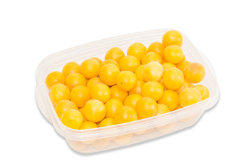 Yellow cherry plum in plastic tray on a light background