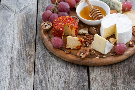 soft cheeses and snacks and wooden background