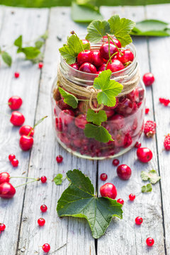 Glass jar full of fruits cherries and currants