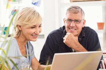 Smiling business team working on laptop