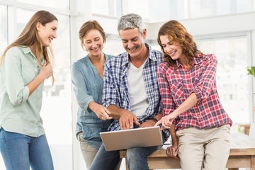 Casual business team having a meeting using laptop