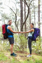 Happy hikers holding hands looking at camera