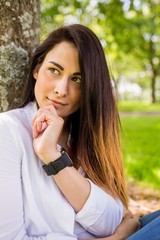 Beautiful brunette thinking in the park