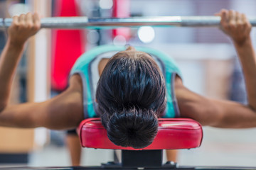 Woman workout with barbell on the bench