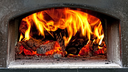 wood burning with flames in a traditional pizza oven.
