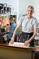Confident Man Using Squeegee In Factory