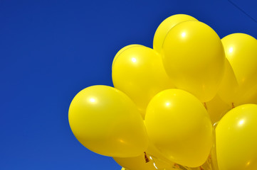 yellow balloons on blue sky background