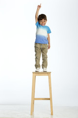little boy standing on a stool