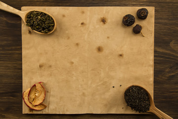black, Oolong in a spoon, dried apples on the old blank open book on wooden background. Menu, recipe, mock up