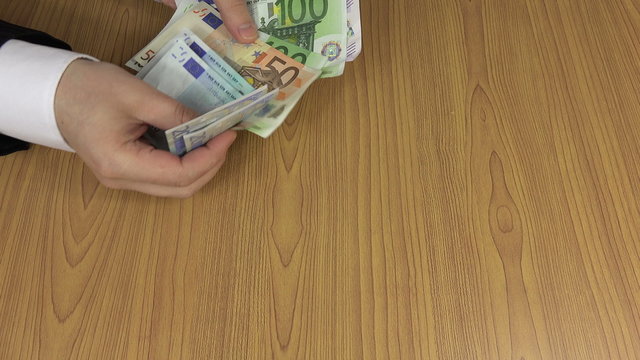 Woman hand give euro cash banknote bribe to clerk man in suit. Officer hand take money from table. Corruption concept. Illegal payment for works. Shadow economy. Closeup shot. 4K UHD video clip.
