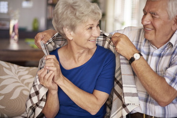 Husband giving warm blanket to his wife