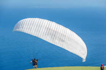 voile blanche de parapente, décollage en tandem 