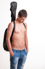 young guitarist wearing no top with his acoustic guitar on back