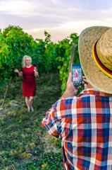 Man photographing woman on smart phone on the background of the
