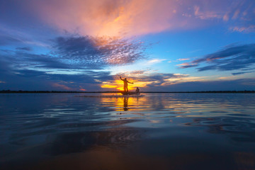Silhouette fisherman with net at the lake in Thailand