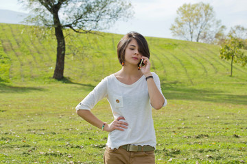 Fototapeta premium Beautiful young woman looks annoyed while talking on the phone