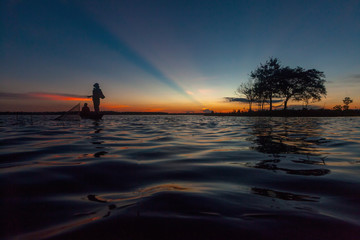 Silhouette throwing fishing net during sunrset, Thailand