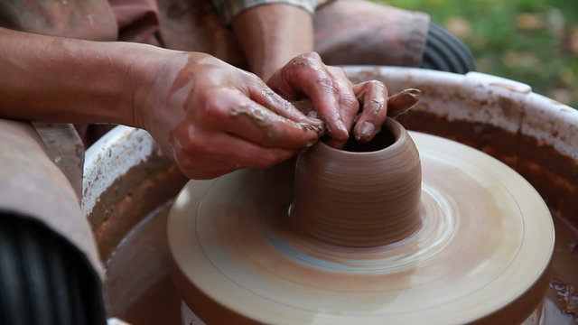 Potter makes a pot on a Potter's wheel. Close-up