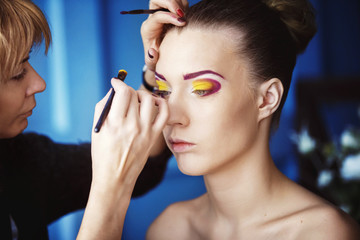 Obraz premium Professional makeup process. Artist is making face style of a yo