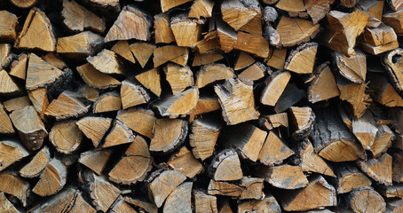 Background of dry chopped firewood logs in a pile