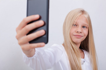 pretty teen girl taking selfies with her smart phone