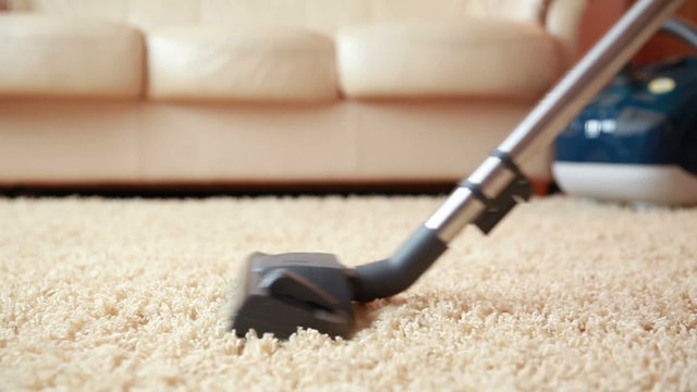 Vacuum cleaner cleaning the carpet, dolly shot