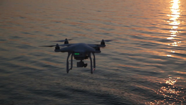 Quadrocopter Flight Over The Water on The River Bank at Sunset