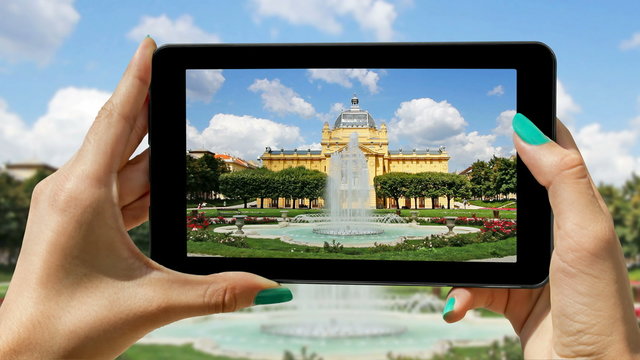 The young girl tourist using a cell phone, records fountain and art pavilion in Zagreb, 4K video