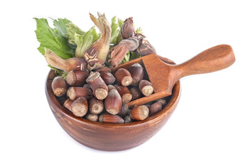 domestic hazelnuts in a wooden bowl on white background