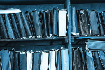 Paper documents stacked on shelf
