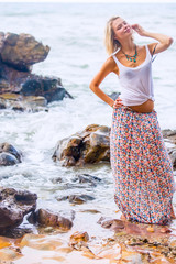 Beautiful young blonde woman posing outdoor at the rocky sea shore