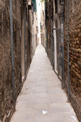 Fototapeta na wymiar A narrow passage between the gloomy houses. Venice is one of the most popular tourist destinations in the world